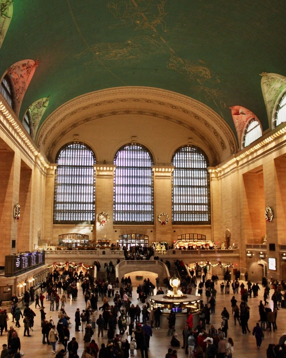 Golden windows and a celestial ceiling above a busy station concourse